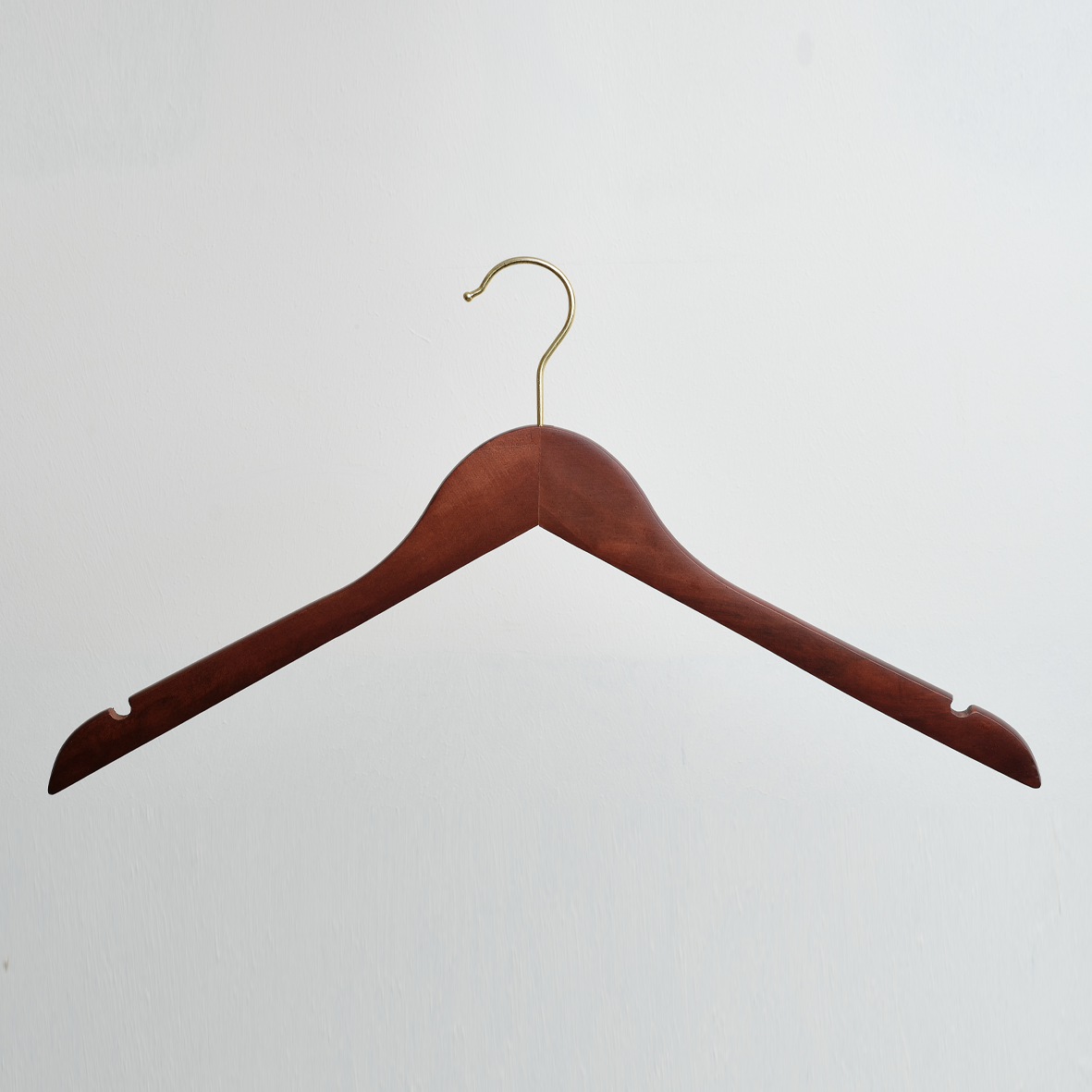 A pack of 100 Dark Wooden 44cm Top Hangers with notches and gold hardware from Hangers of London is displayed against a plain white background.