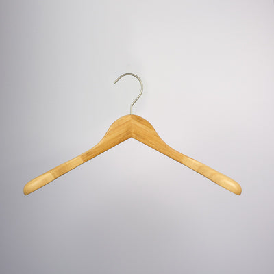 A Hangers of London Bamboo Wood Sustainable Top Jacket Hanger 42cm with a metallic hook is suspended against a plain gray background. The hanger is simple in design, featuring a natural wood finish with smoothly curved shoulders, offering an eco-friendly clothing organization solution.