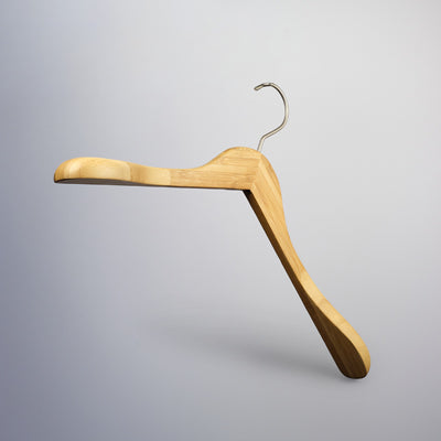 A Hangers of London Bamboo Wood Sustainable Top Jacket Hanger 42cm with a curved design and metal hook is suspended against a plain, light gray background, perfect for eco-friendly clothing organization.