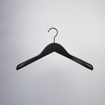 A single, Hangers of London Black Wooden Jacket Top Coat Hanger 38cm is suspended against a plain, light gray background. This high-quality hanger features broad, slightly curved shoulders and a metal hook at the top.