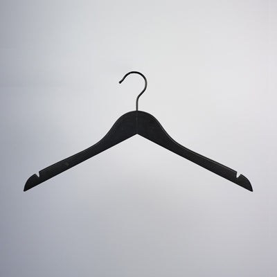 A Black Wooden Top Clothes Hanger with Notch 44cm by Hangers of London is suspended on a light grey background. This elegant hanger features wide, curved shoulders and shoulder notches on both arms for securing strapped garments, making it one of the ideal clothing storage solutions.