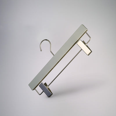 A minimalist white, Hangers of London Premium Soft Touch Plastic Clip Hanger 35cm with a metal hook and two silver clips, suspended against a plain gray background. The clips are positioned on the bottom bar of the hanger, designed to hold pants or skirts – a stylish storage solution for any wardrobe.