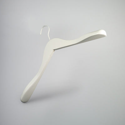 A white wooden jacket top coat hanger 44cm from Hangers of London is isolated against a plain gray background. Mimicking the style of a White Wooden Jacket Top Coat Hanger 44cm, it has a broad, contoured shape designed to maintain the structure of garments.