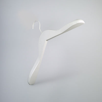 A minimalist, Hangers of London White Wooden Jacket Top Coat Hanger 38cm with a sleek, modern design hangs against a plain, light gray background. Ideal for wardrobe organization, this hanger features clean lines and a smooth surface, giving it an elegant and contemporary appearance.