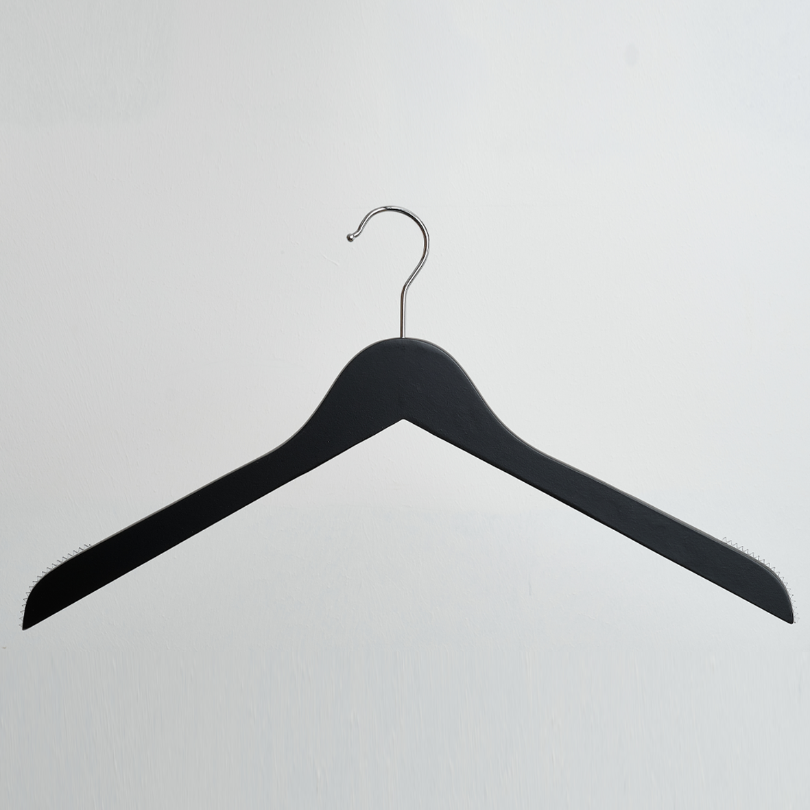 The image shows the Hangers of London 44cm Black Wooden Top Hanger with Non Slip Grips (Pack of 100), featuring a sleek black finish and a silver metal hook, displayed against a plain white background.