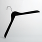 A 44cm Black Wooden Top Hanger with Non Slip Grips from Hangers of London (Pack of 100) is positioned at an angle against a plain white background, creating a minimalist and abstract composition.