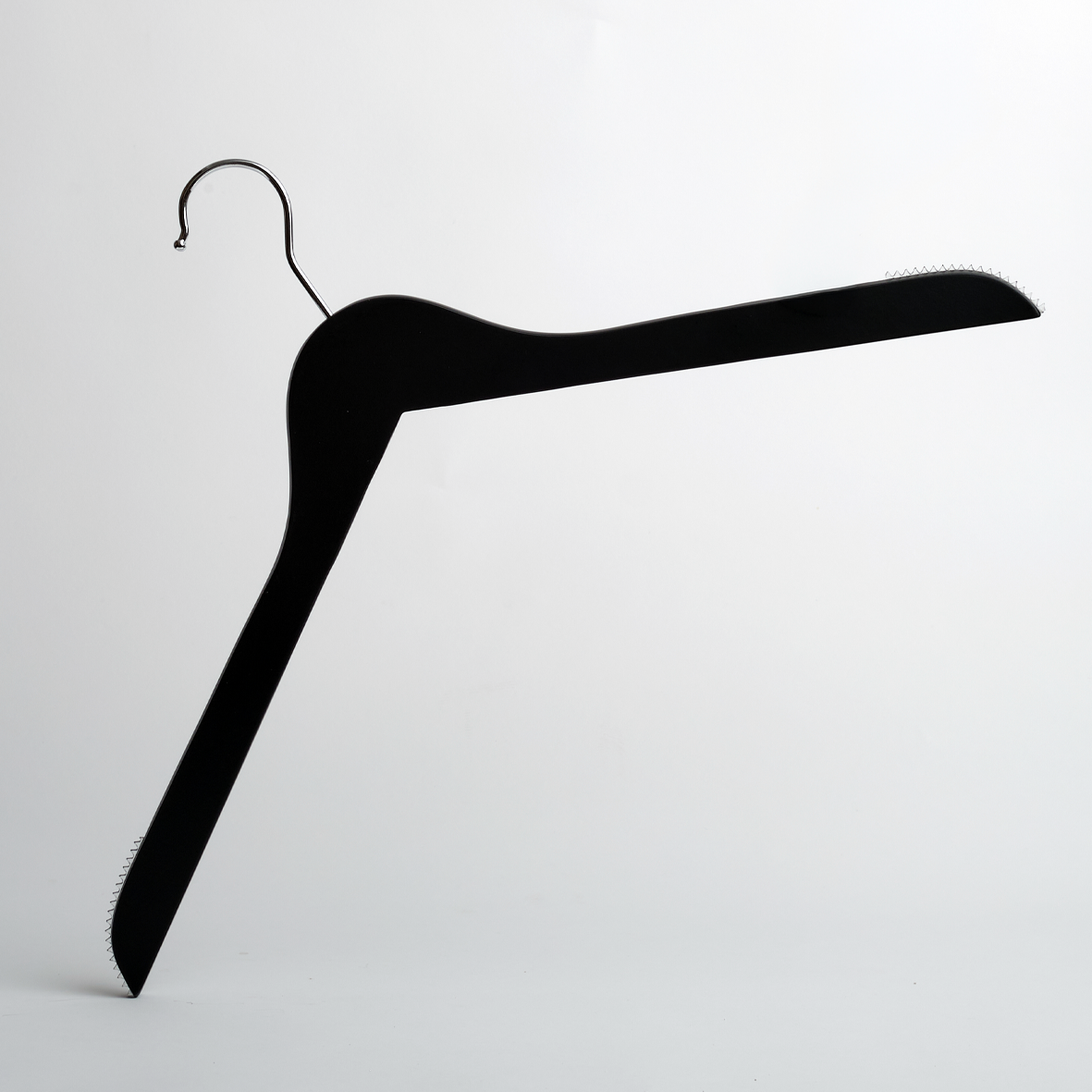 A 44cm Black Wooden Top Hanger with Non Slip Grips from Hangers of London (Pack of 100) is positioned at an angle against a plain white background, creating a minimalist and abstract composition.