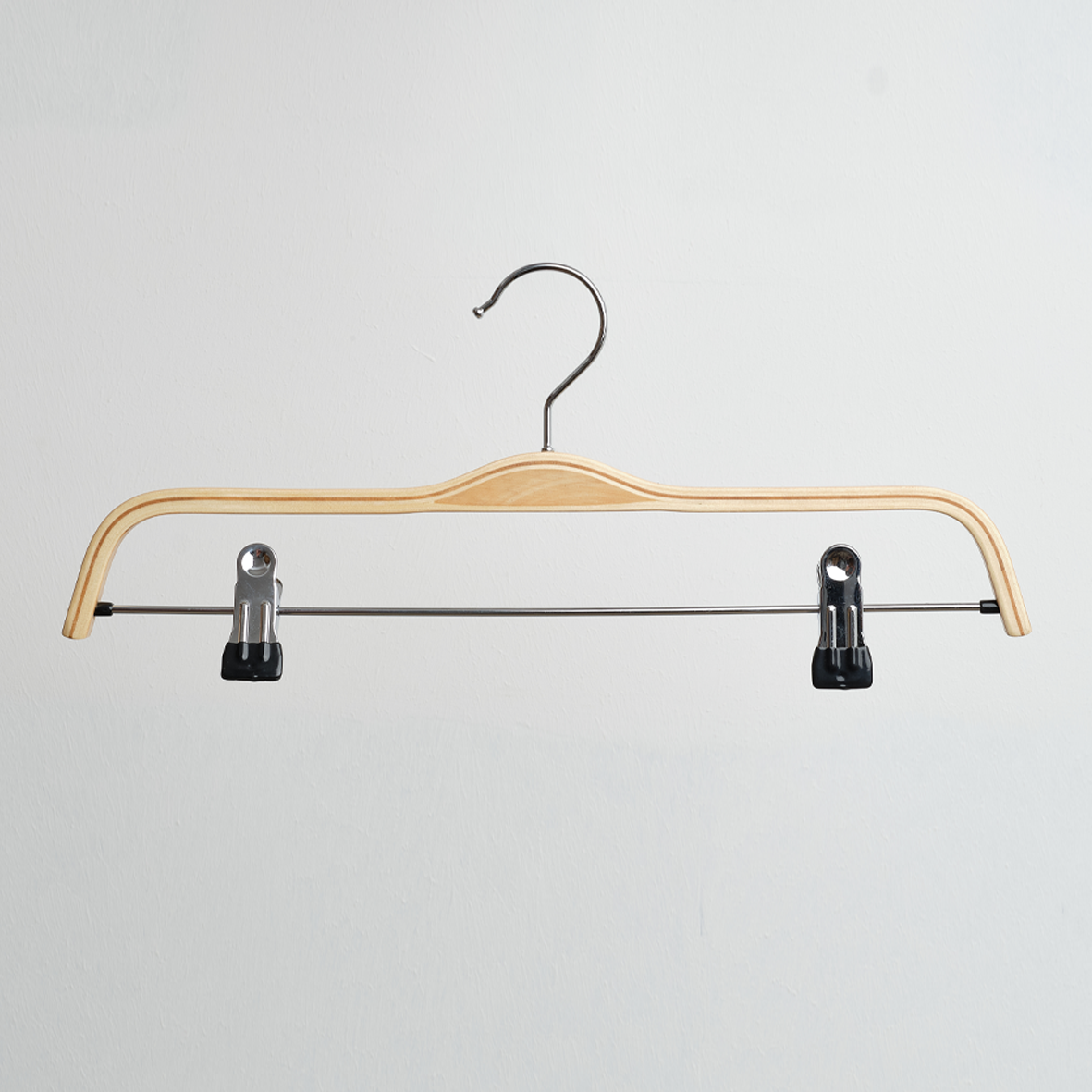 The Scandi Style Laminated Wooden 37cm Clip Hanger by Hangers of London, featuring a sturdy metal hook and an attached metal bar with two black adjustable clips, is shown hanging against a plain white background.