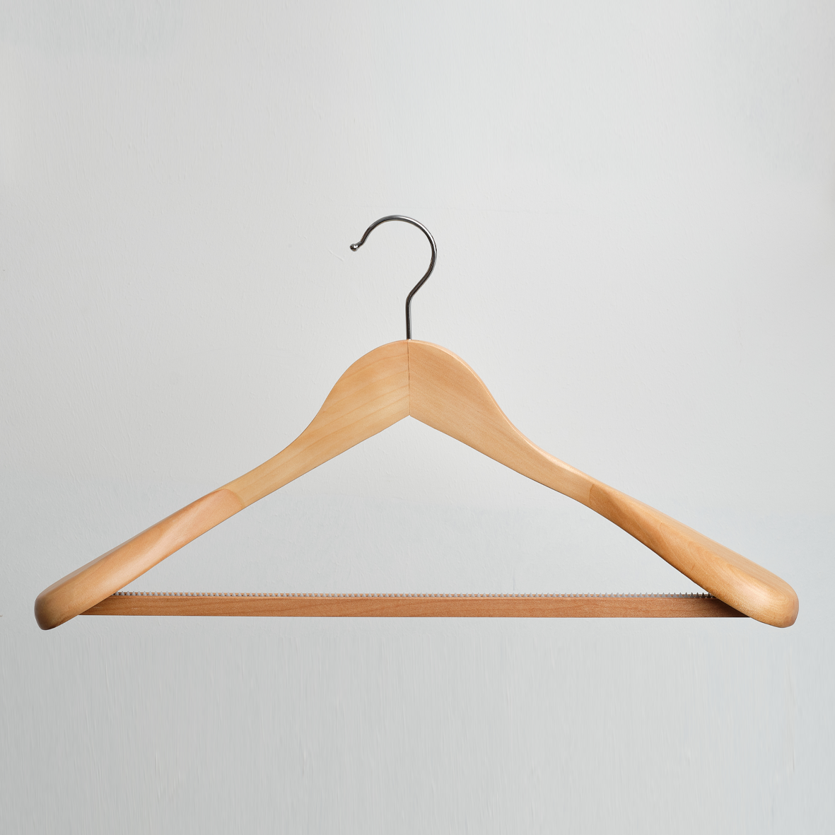The Hangers of London Natural Wooden 45cm Jacket Hanger with Trouser Bar (Pack of 24) is displayed against a plain light gray background, featuring a sturdy wooden construction and a metal hook.