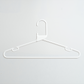 A Heavy Duty Economy White Multi Purpose Rainbow Hanger from Hangers of London is hanging on a plain, light-colored wall.