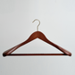 A Dark Wooden 45cm Jacket Hanger With Trouser Bar Gold Hardware by Hangers of London is displayed against a plain white background, showcasing its broad shoulders and horizontal bar for trousers.
