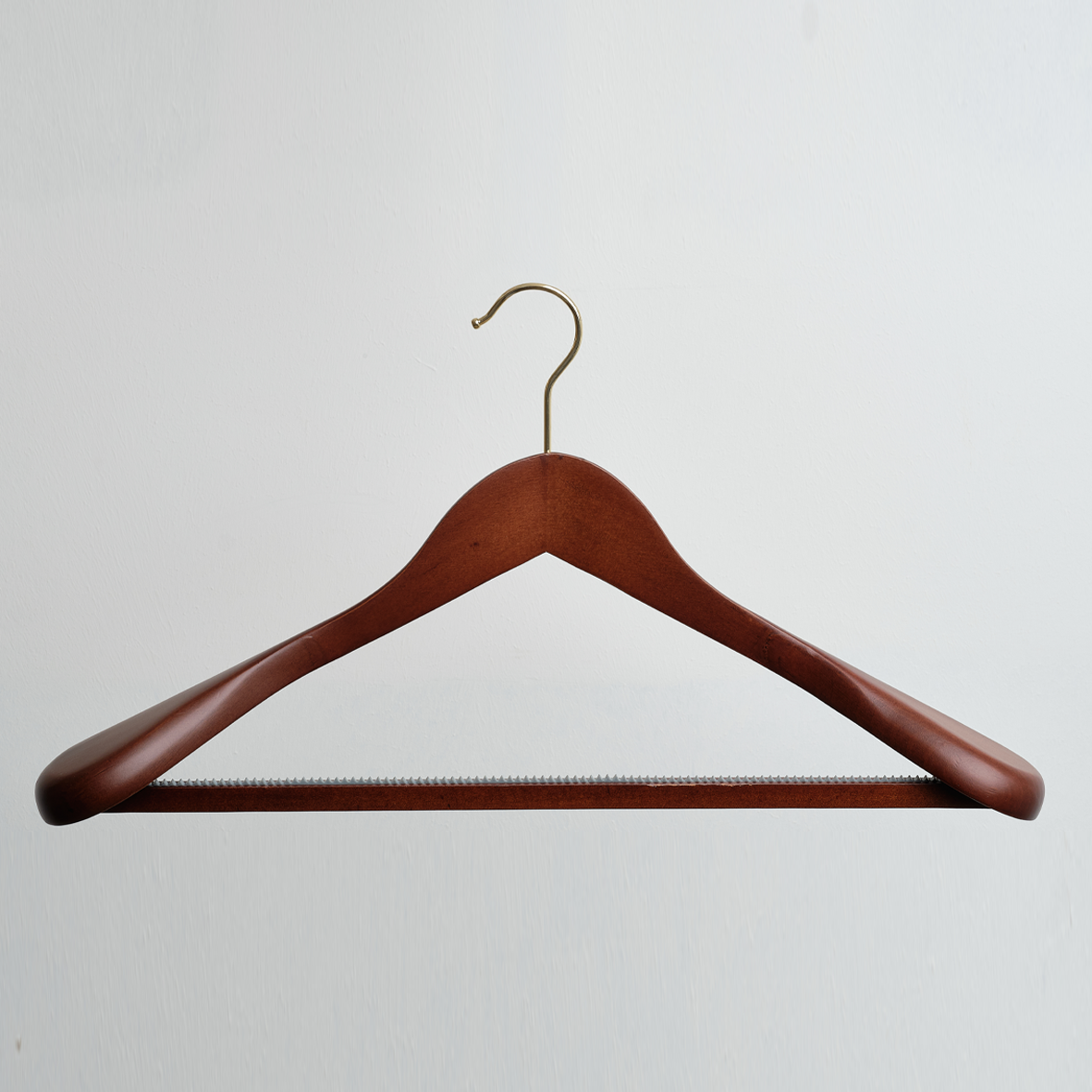 A Dark Wooden 45cm Jacket Hanger With Trouser Bar Gold Hardware by Hangers of London is displayed against a plain white background, showcasing its broad shoulders and horizontal bar for trousers.