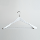 A White Wooden 45cm Jacket Hanger With Non Slip Trouser Bar by Hangers of London, featuring a metal hook, is displayed against a plain, light-colored wall.