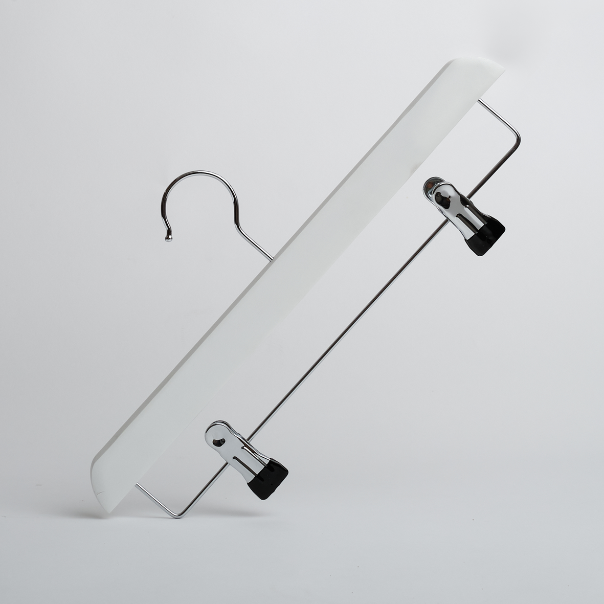 A Hangers of London White Wooden 35cm Clip Hanger, featuring two black clips, is positioned diagonally against a plain white background.
