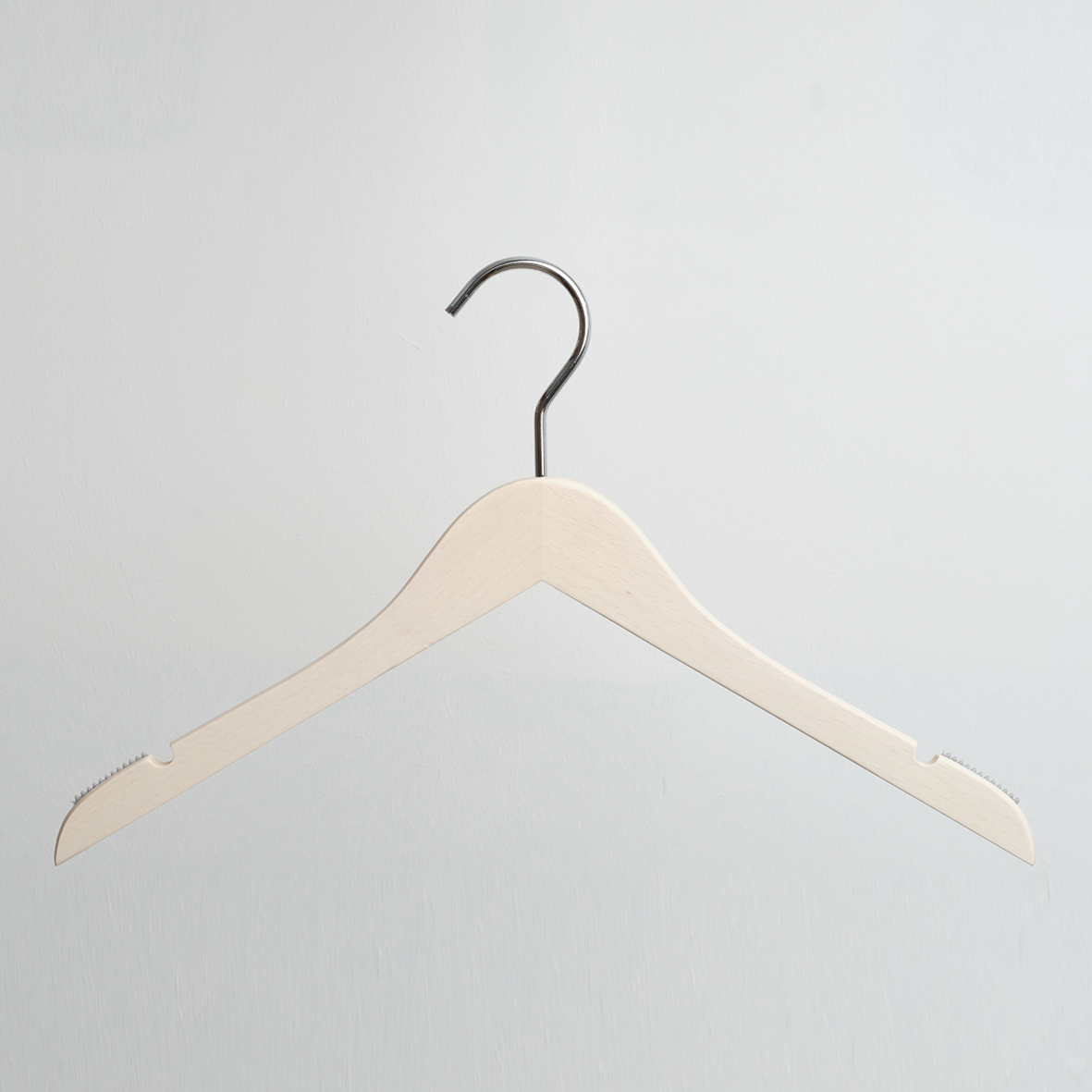 A Luxury Whitewashed Beech Wooden 42cm Top Hanger With Notches from Hangers of London is hanging against a light gray background.