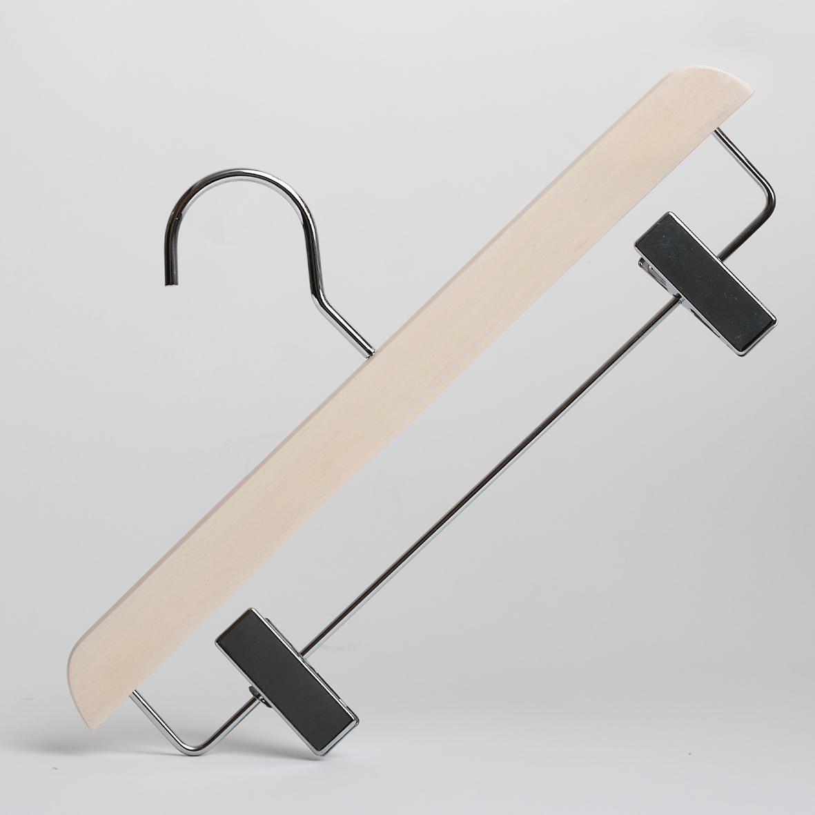 The Hangers of London Luxury Whitewash FSC Certified Beech Wooden 35cm Clip Hanger, featuring a metal hook and two black adjustable clips for hanging pants or skirts, is displayed against a plain white background.